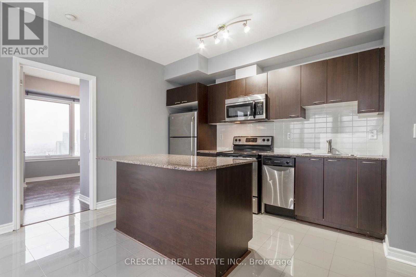 A kitchen with a brown counter and stainless steel appliances.