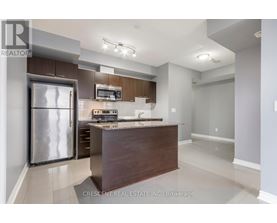 A modern kitchen with a refrigerator, microwave, and oven.