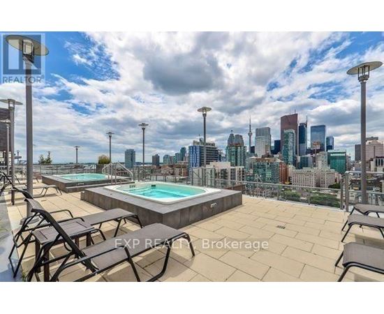 A rooftop with a pool and chairs overlooking a city skyline.