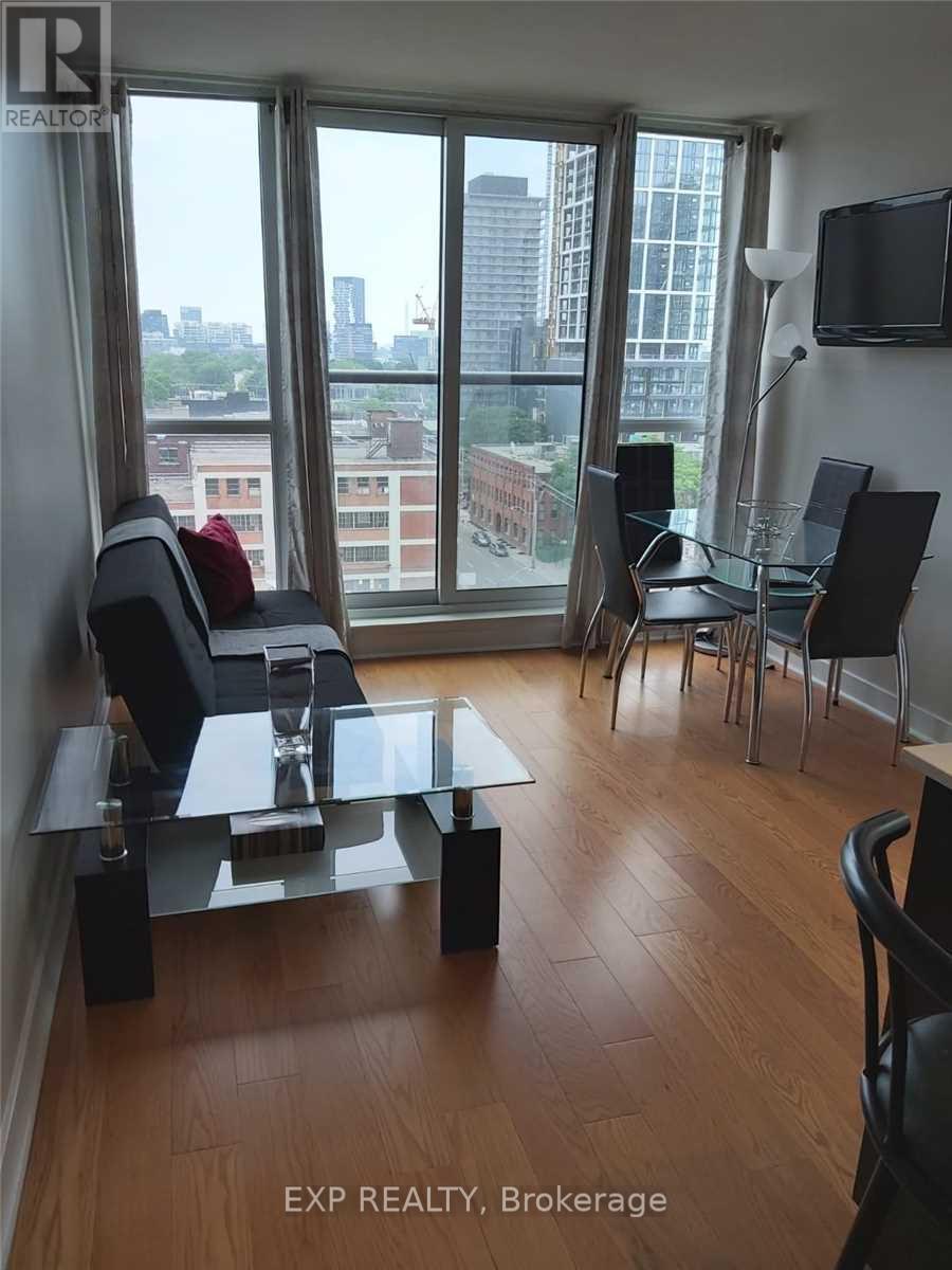 A living room with a glass table and chairs with a view of the city.