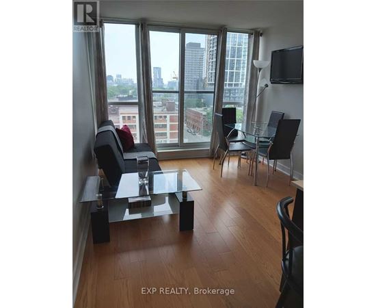 A living room with a glass table and chairs with a view of the city.