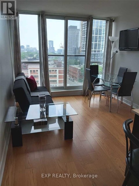 A living room with a glass table and chairs with a view of the city.