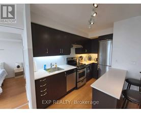 A kitchen with black cabinets and stainless steel appliances.