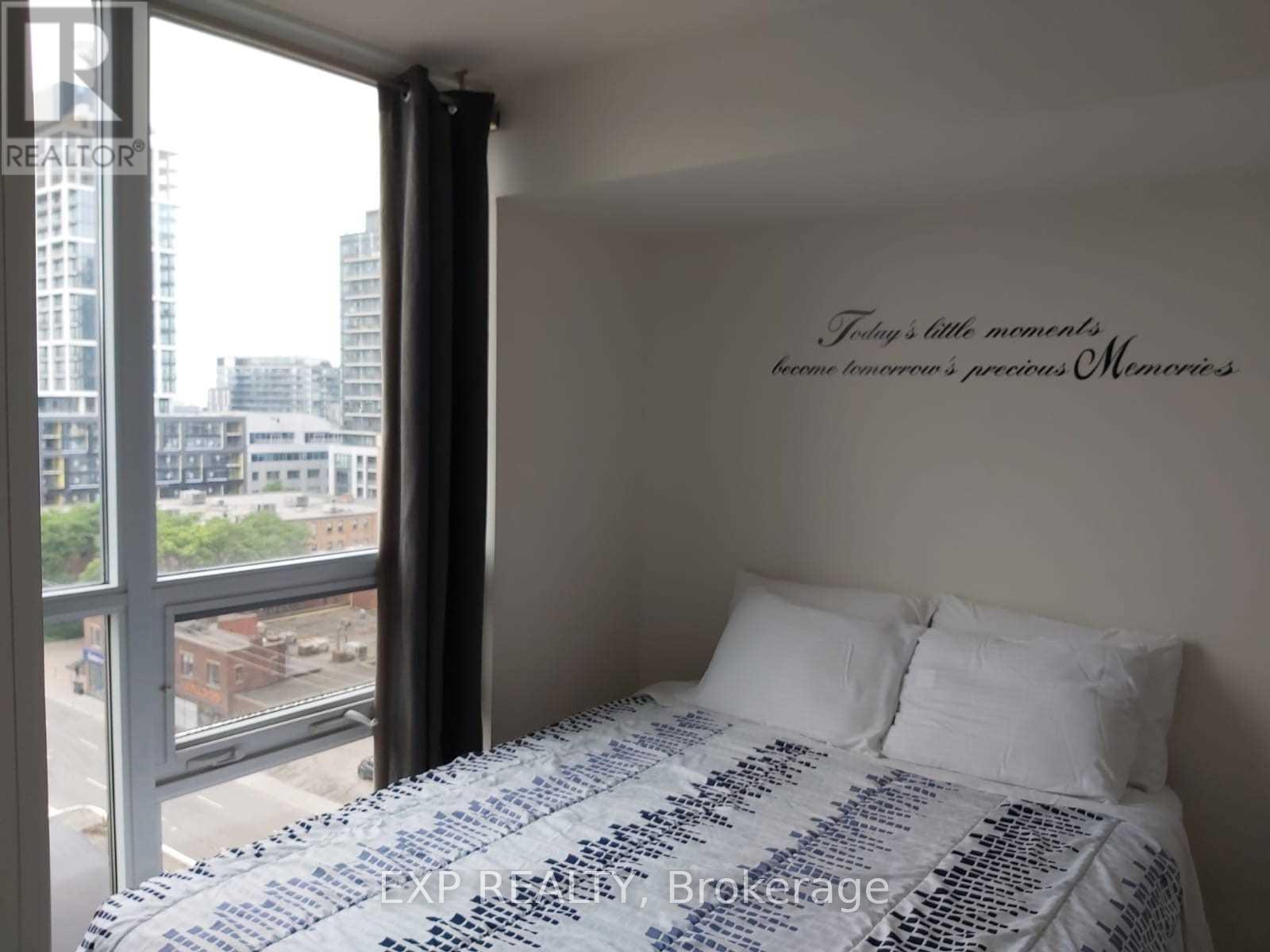 A bedroom with a large bed and a window overlooking a cityscape.