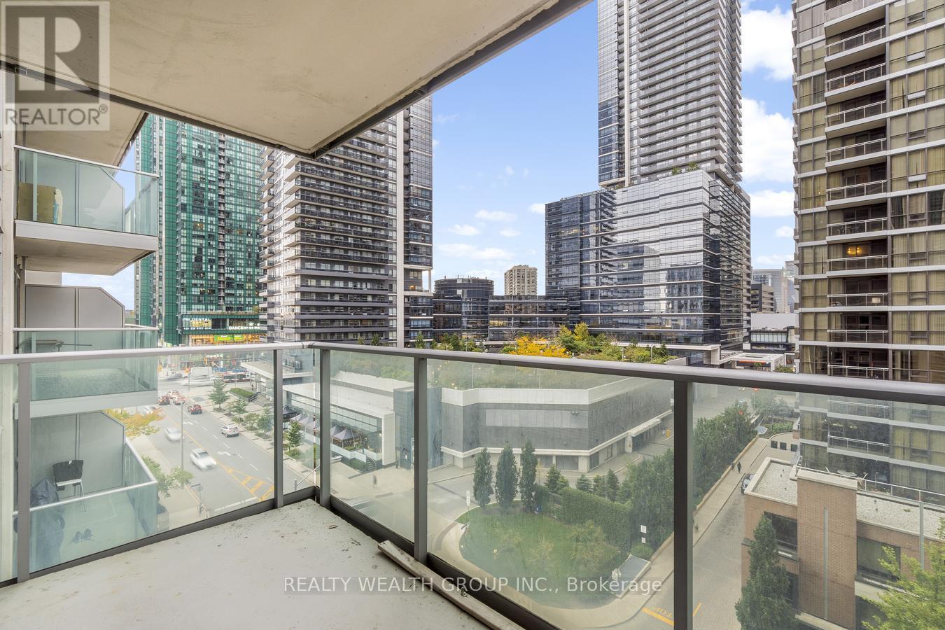 A balcony with a glass railing overlooks a cityscape.