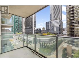A balcony with a glass railing overlooks a cityscape.