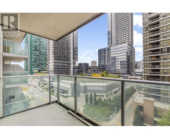 A balcony with a glass railing overlooks a cityscape.
