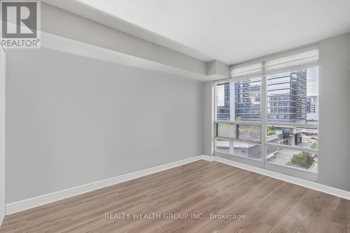 A spacious room with a view of the cityscape through the windows.