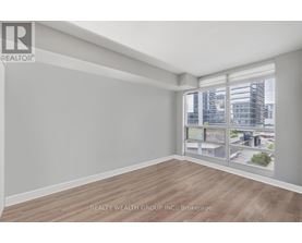 A spacious room with a view of the cityscape through the windows.