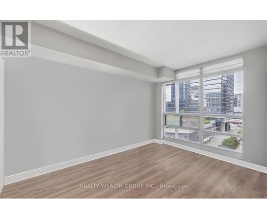 A spacious room with a view of the cityscape through the windows.