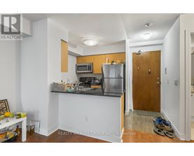 A kitchen with a refrigerator, microwave, and sink.