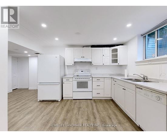 A white kitchen with wooden floors and white appliances.