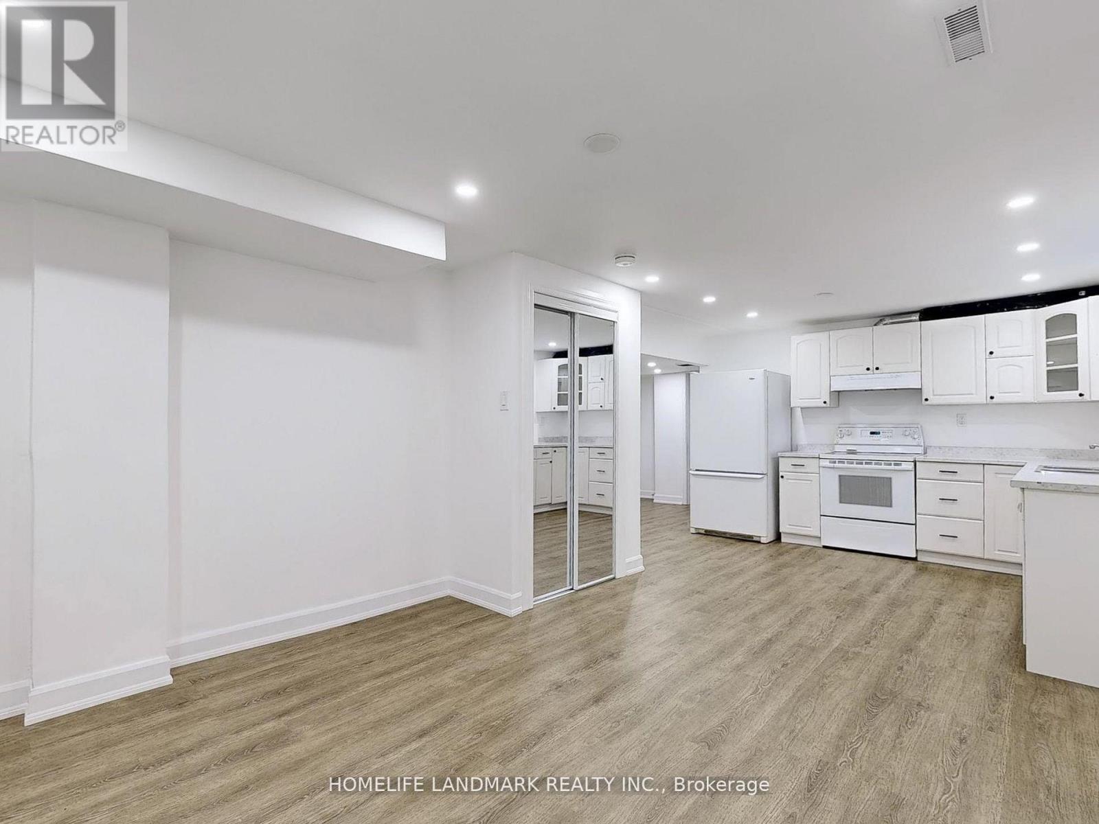 A spacious kitchen with white cabinets and appliances.