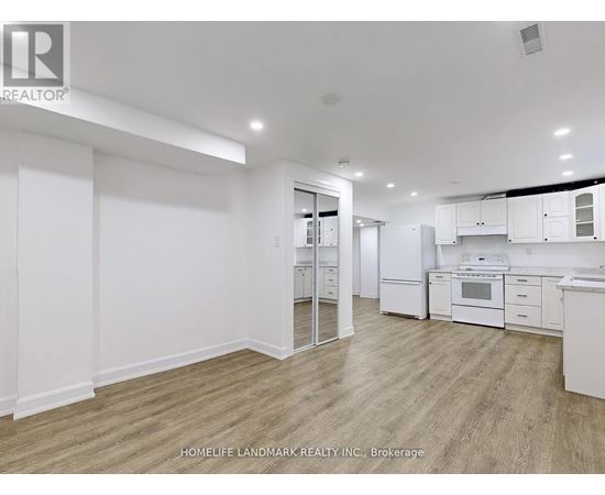 A spacious kitchen with white cabinets and appliances.