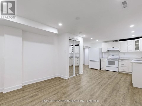 A spacious kitchen with white cabinets and appliances.