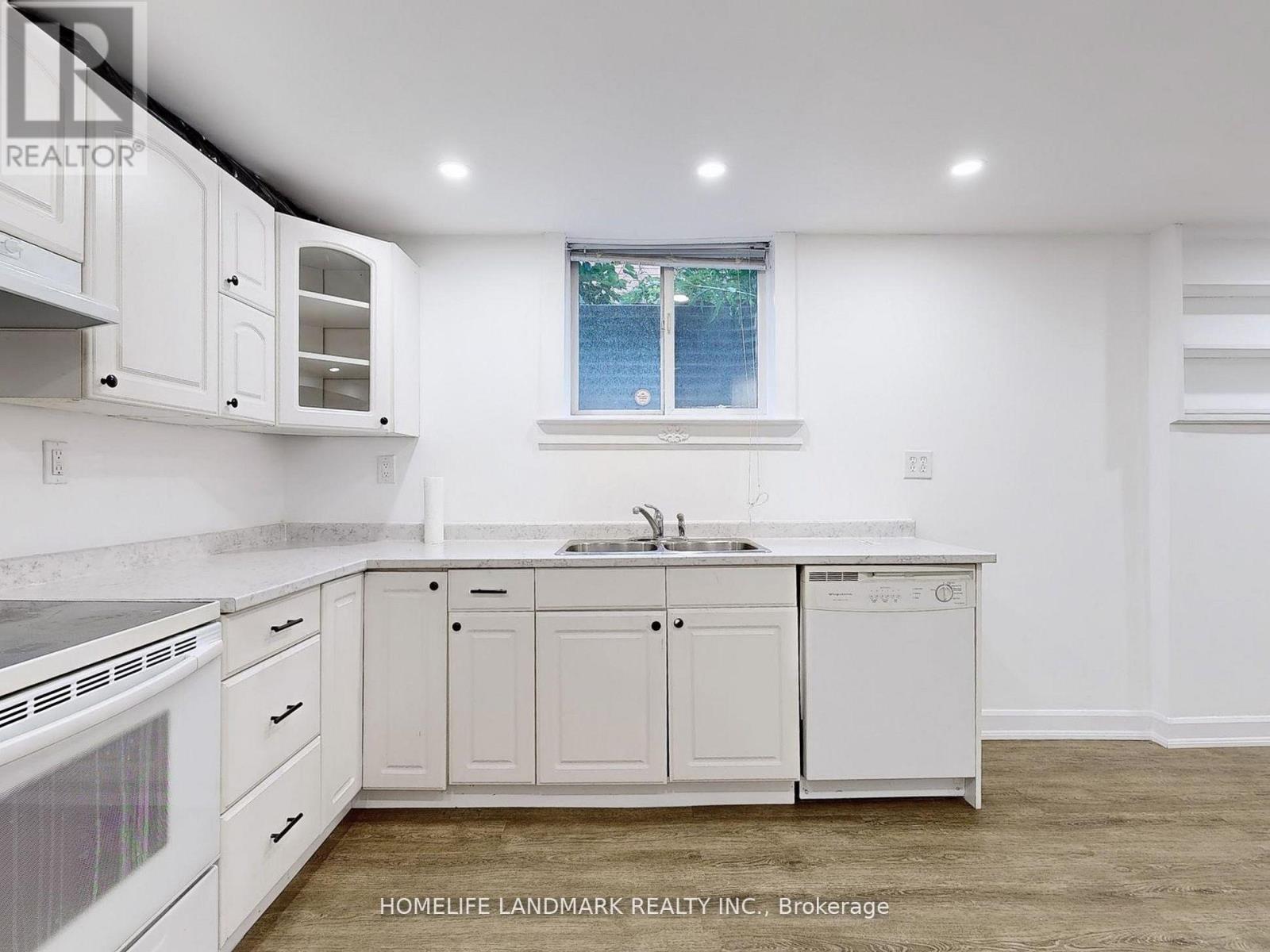 A white kitchen with a window and a sink.