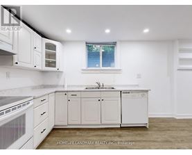 A white kitchen with a window and a sink.