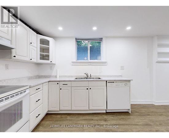 A white kitchen with a window and a sink.
