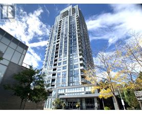 A tall glass building with trees in front of it.