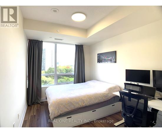 A bedroom with a bed, desk, and chair.