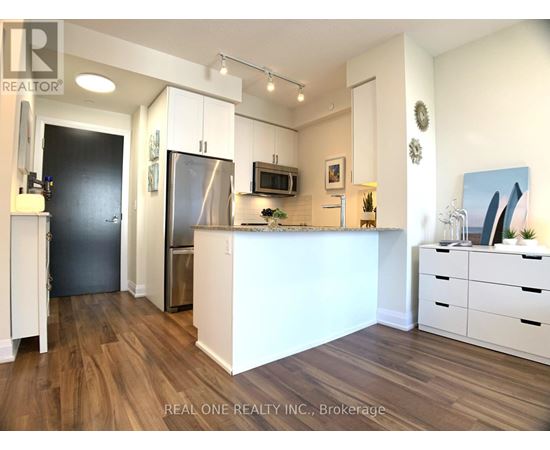 A kitchen with white cabinets and a wooden floor.