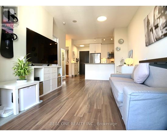 A living room with a grey couch and a wooden floor.