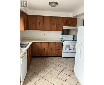A kitchen with white appliances and brown cabinets.