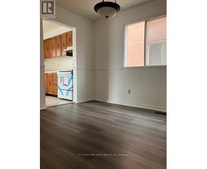 A room with wooden floors and a window with white curtains.