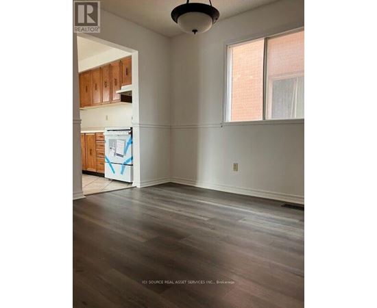 A room with wooden floors and a window with white curtains.