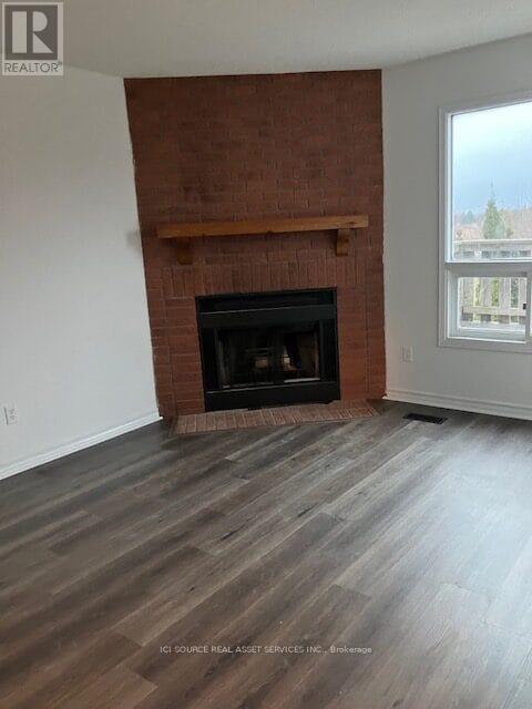 A room with a fireplace and wooden flooring.
