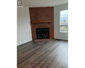 A room with a fireplace and wooden flooring.