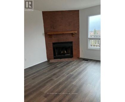 A room with a fireplace and wooden flooring.