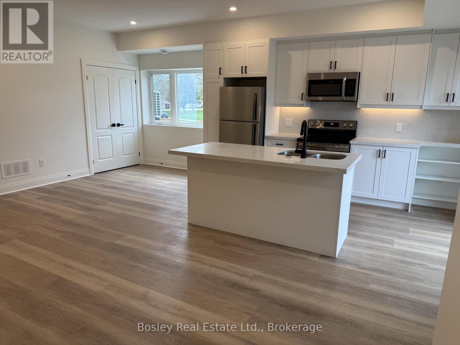 A kitchen with a white island and wooden floors.