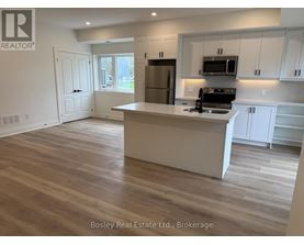 A kitchen with a white island and wooden floors.