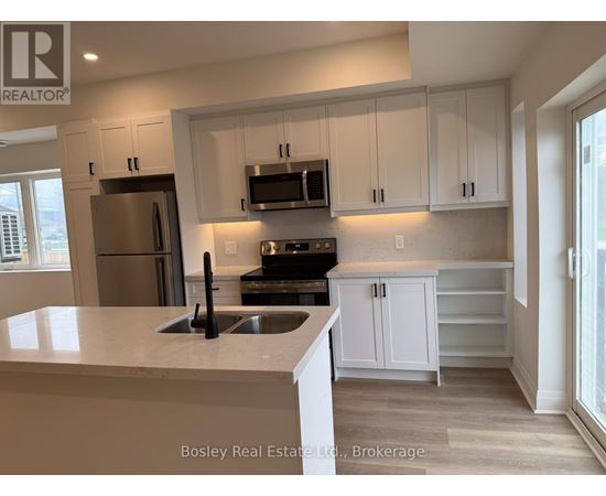 A kitchen with white cabinets and a marble countertop.