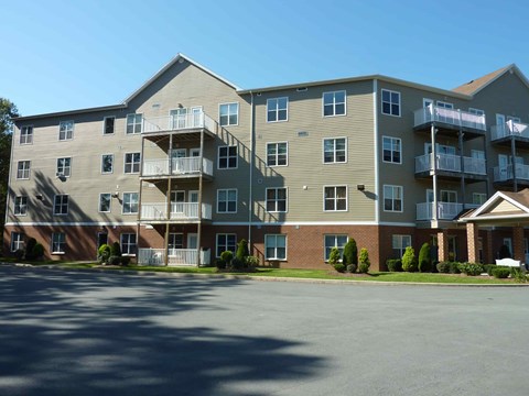 A large apartment complex with a parking lot in front.