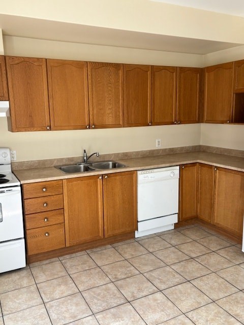 A kitchen with wooden cabinets and a white dishwasher.