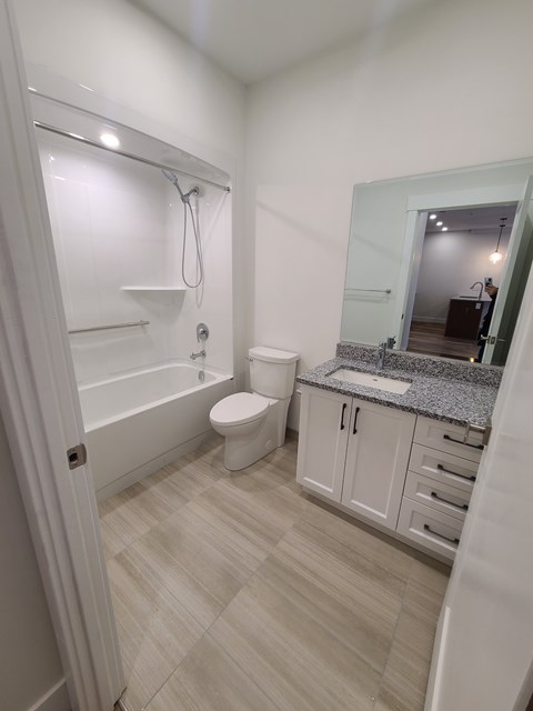 A white bathroom with a toilet, sink, and bathtub.