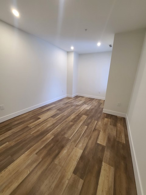 A room with wooden flooring and white walls.