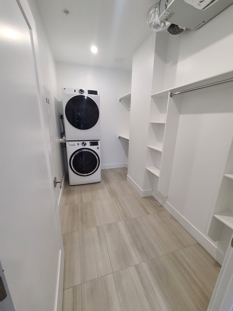 A laundry room with a washer and dryer stacked on top of each other.