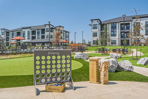 Outdoor games area with oversized connect four and jenga at The Westerly Apartments, Texas, 76065