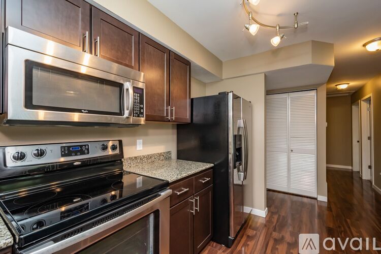 A kitchen with a black refrigerator and stainless steel appliances.