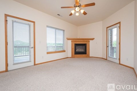 A spacious room with a fireplace and a ceiling fan.