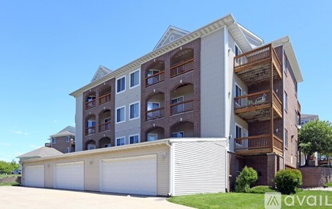 A large apartment building with multiple balconies and garage doors.