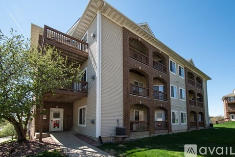 A multi-story apartment building with a balcony on the second floor.