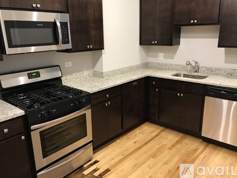 A kitchen with dark wood cabinets and stainless steel appliances.