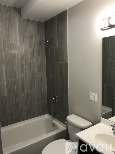A bathroom with a tub, toilet, and sink.