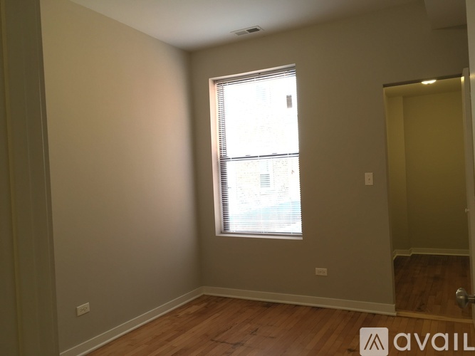 A room with a window and wooden flooring.