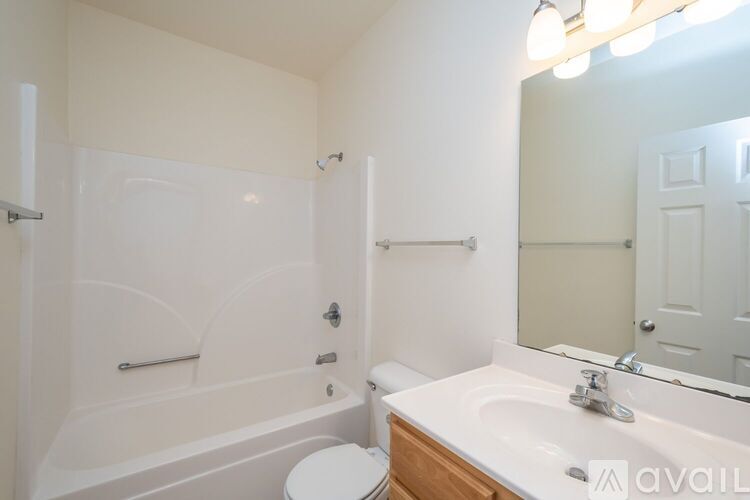 A white bathroom with a toilet, sink, and bathtub.