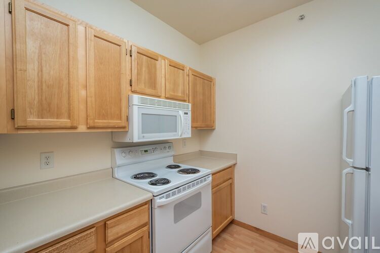 A kitchen with wooden cabinets and white appliances.